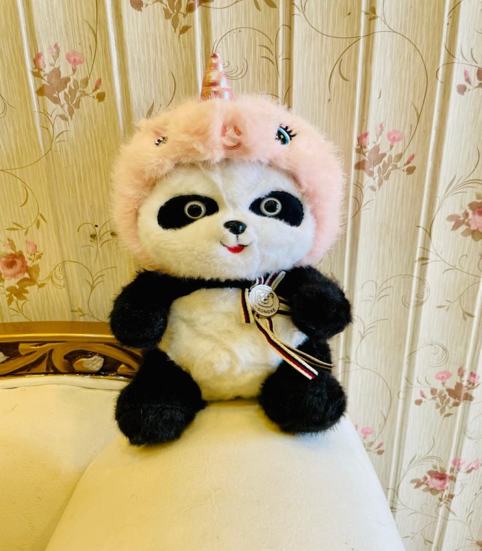 Cute unicorn panda teddy bear with pink hood sitting on sofa