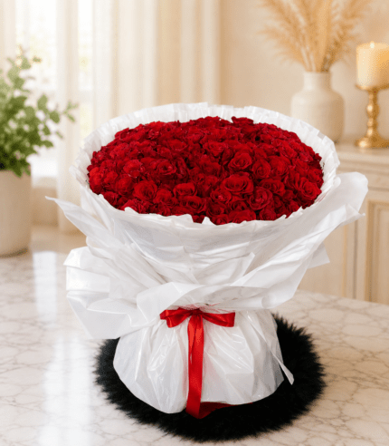 Red rose bouquet with white wrapping and red ribbon in Pakistan